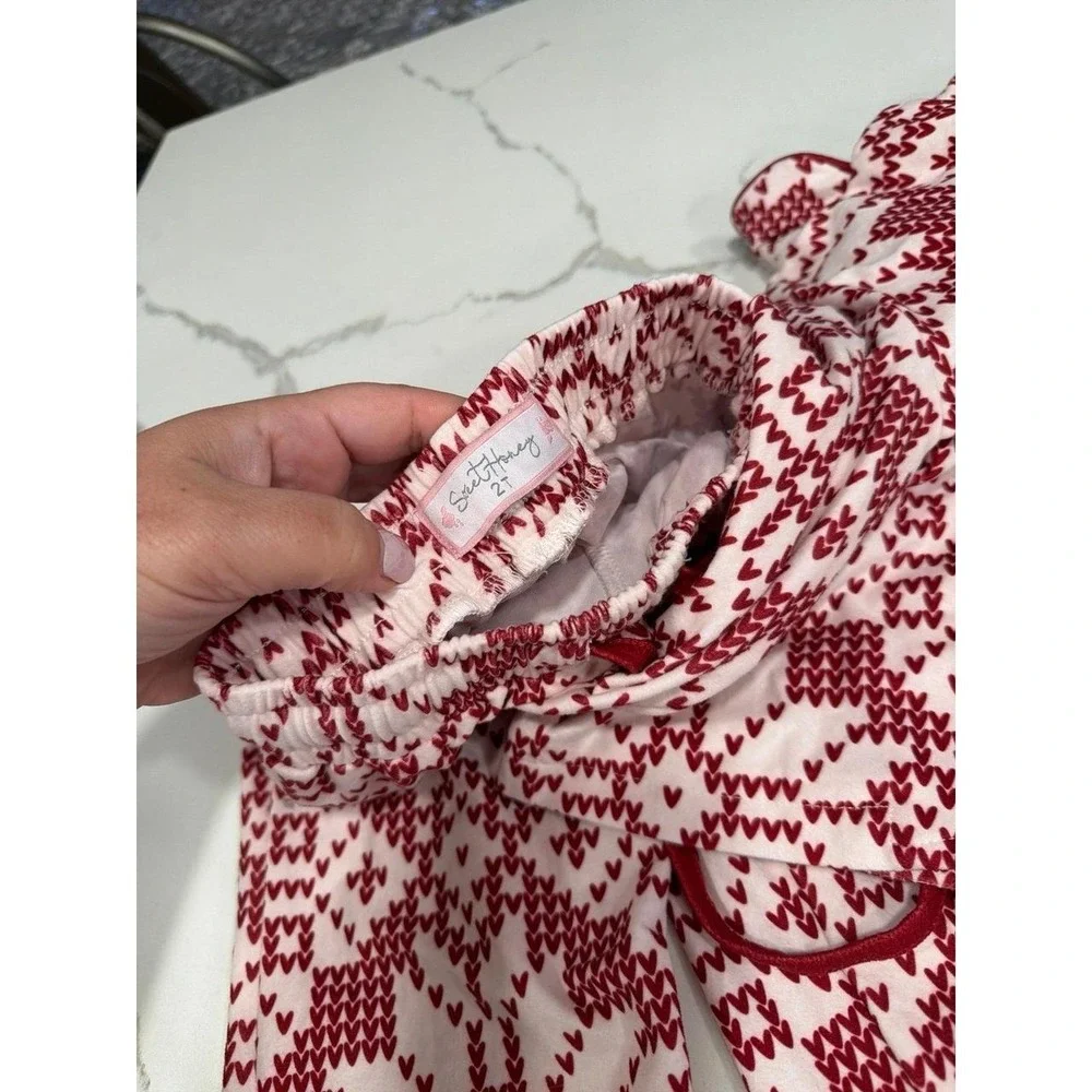 Sweet Honey pajama set features a festive red and white snowflake pattern 2T
